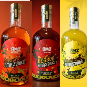 Two bottles of AMZ Tropical Negroni Amazônico beside a rocks glass