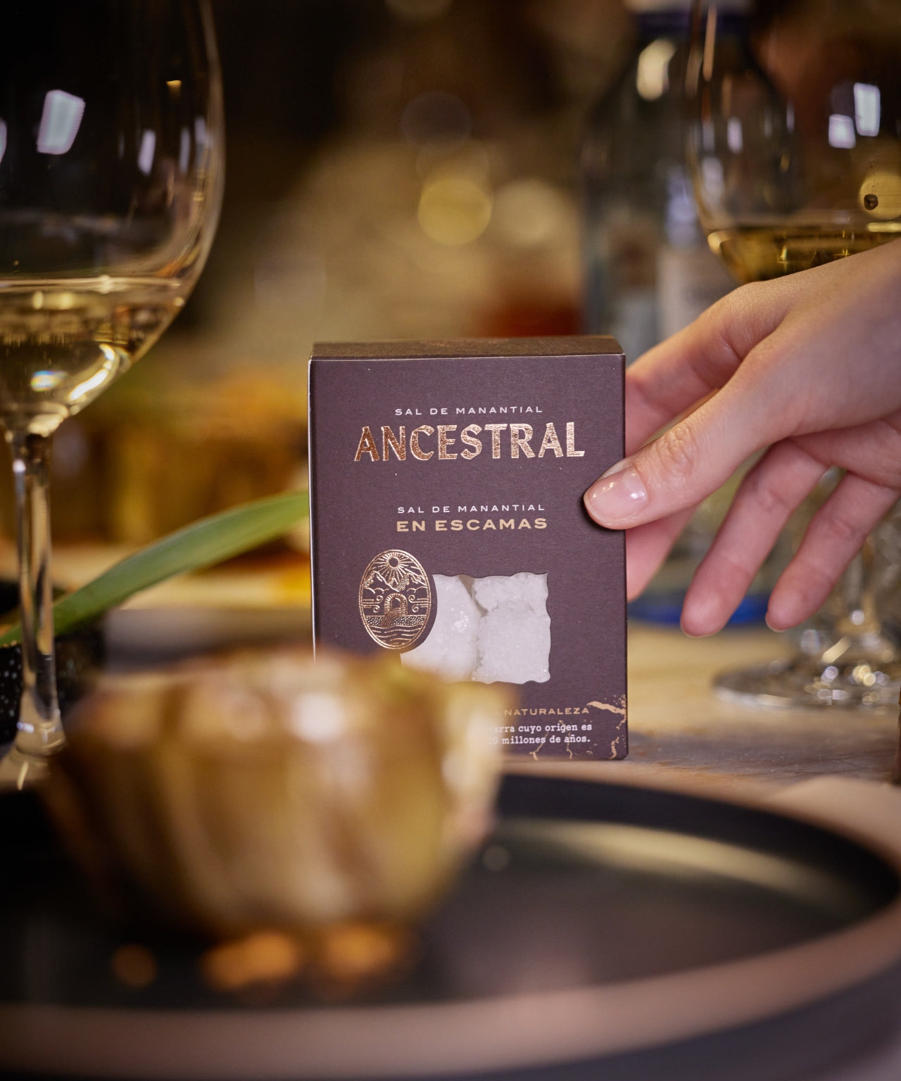 Ancestral spring salt flakes in a purple carton on a dining table