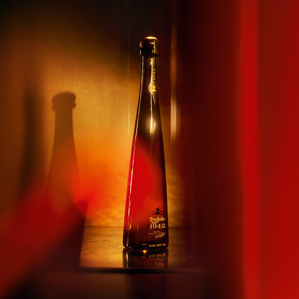 Don Julio 1942 tequila bottle against a warm red and gold background